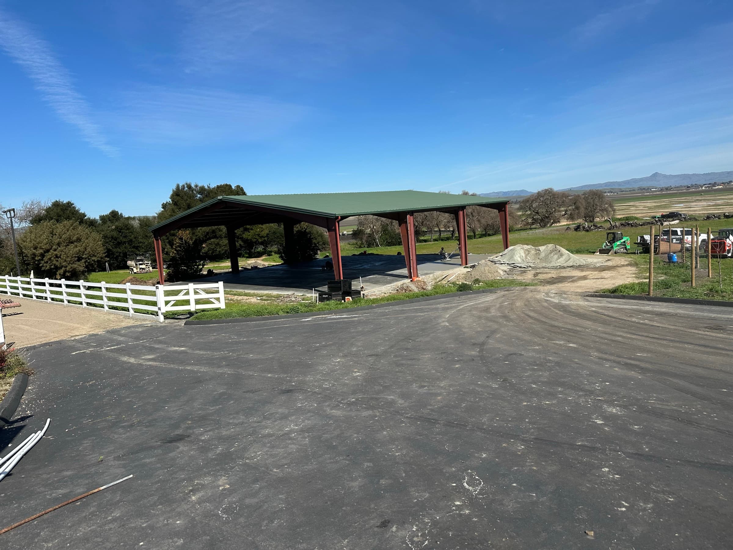 Timber pavilion with a green metal roof overlooking the valley