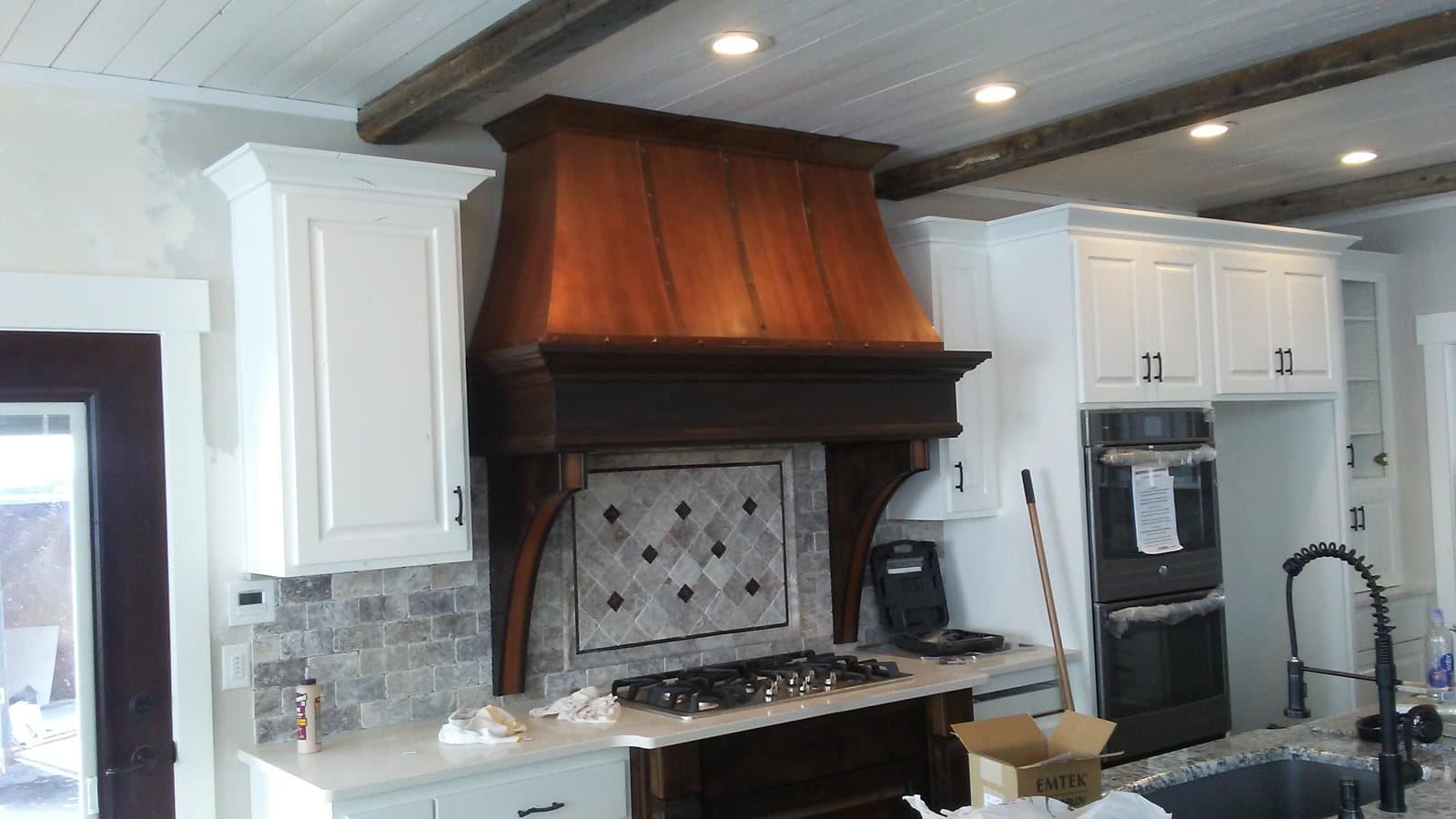 Custom wood range hood with carved corbels